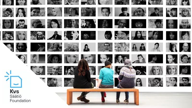 three people sitting on a bench and looking at a photo wall with lots of faces.