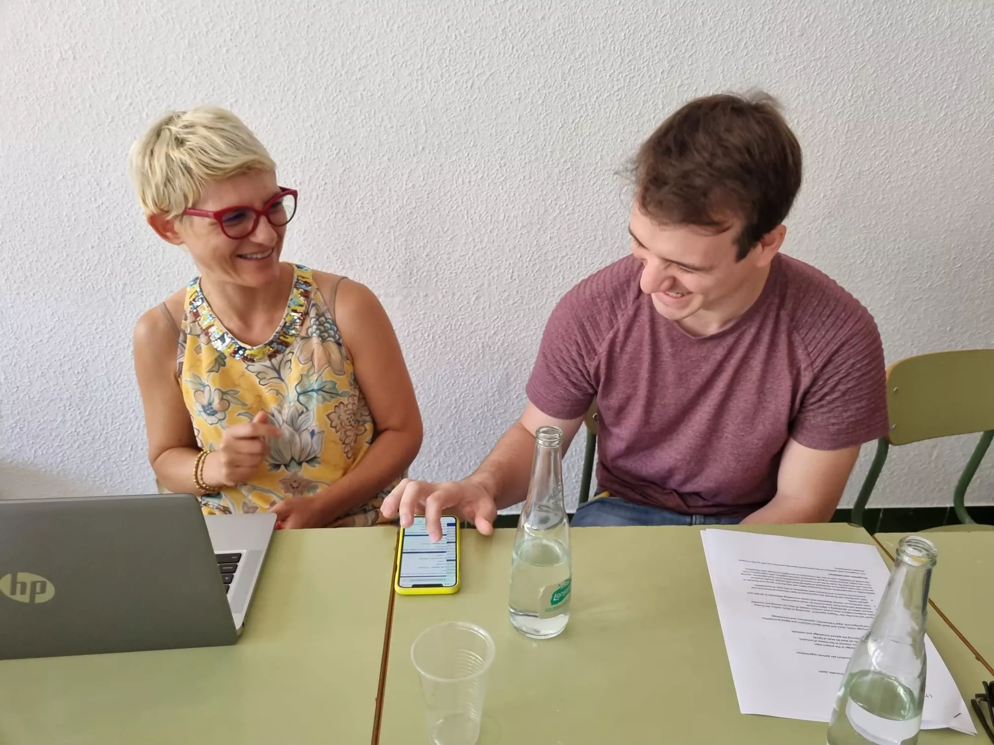 Partecipanti all'attività LTTA a La Zubia, Spagna. Due persone sorridenti guardano il telefono durante un'attività per migliorare le competenze digi...