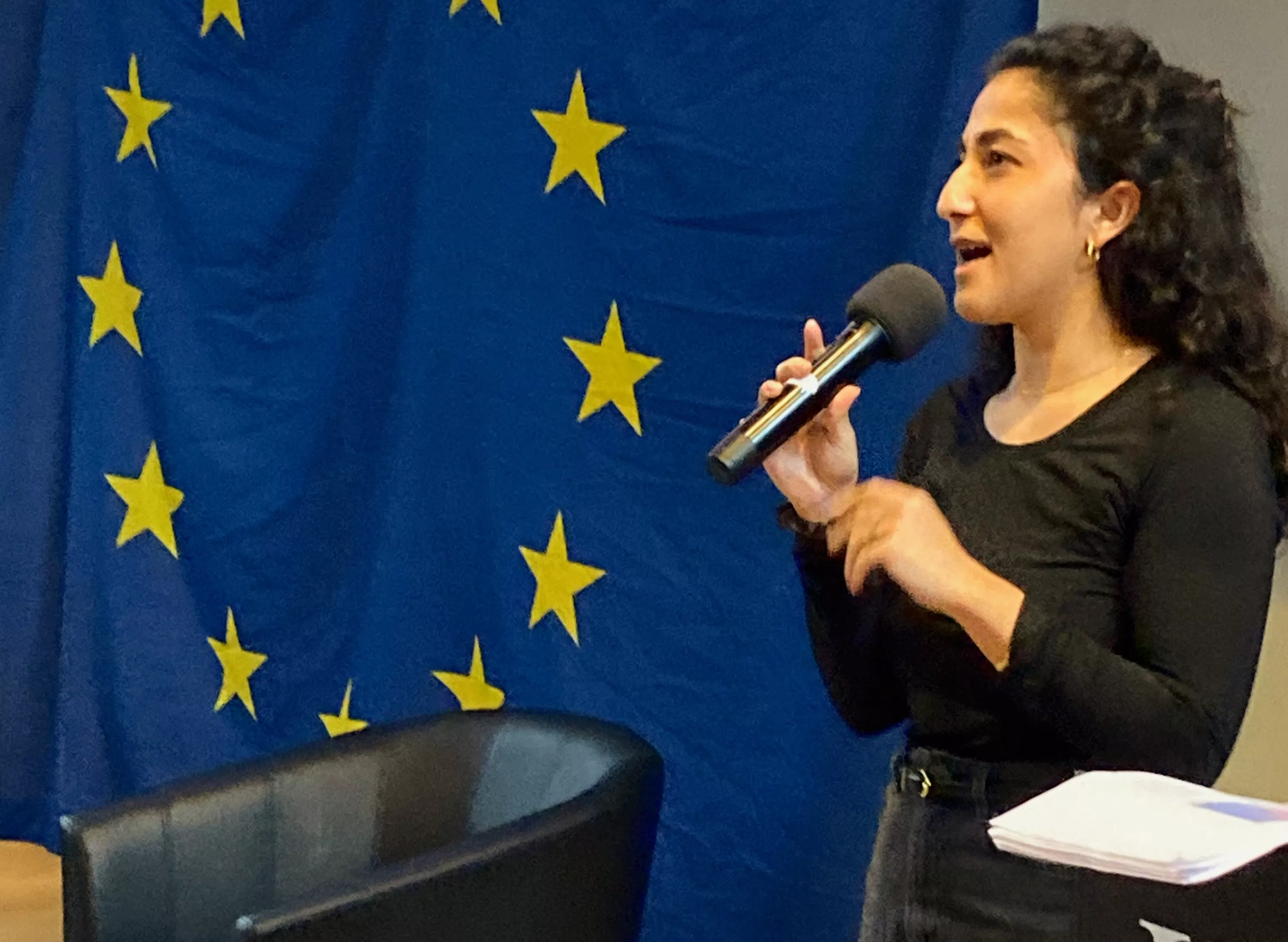 Aida Badeli framför en EU-flagga.
