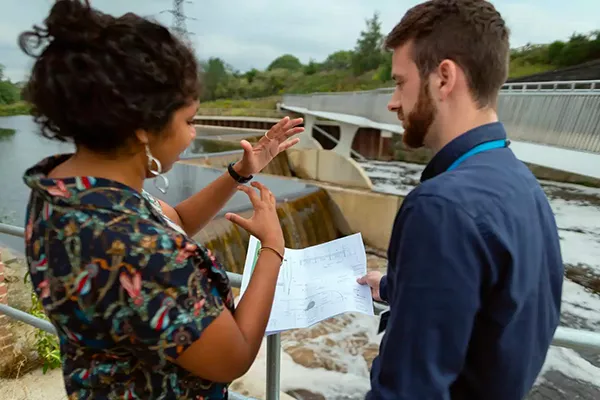Une femme et un homme discutent, une feuille à la main.