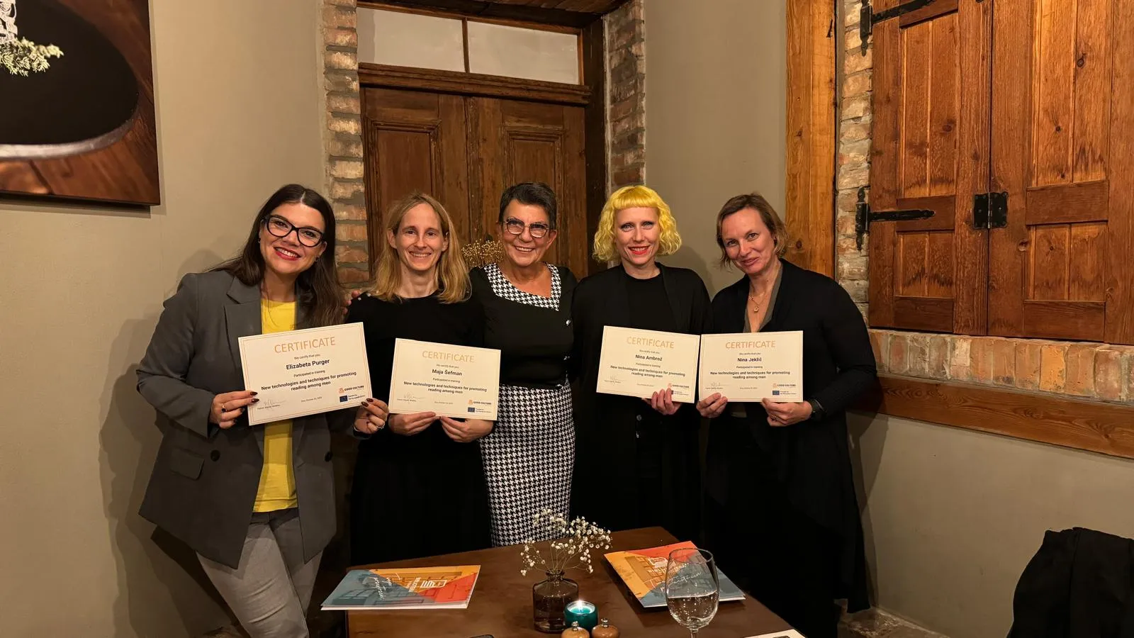 The Slovenian team posing with the director of the Żory Library, holding certificates.
