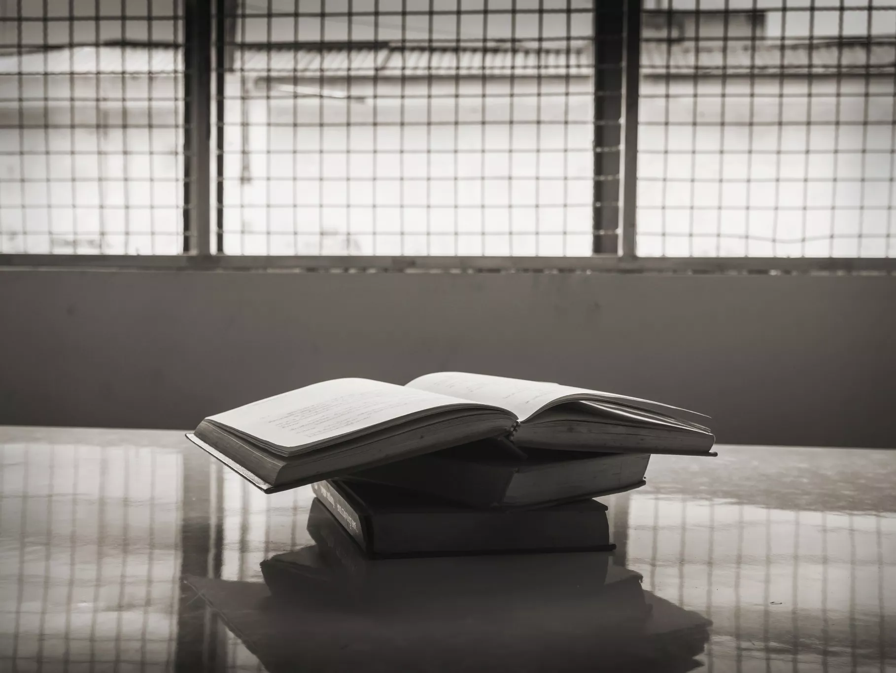 A photo of a pile of books on a table in a prison.