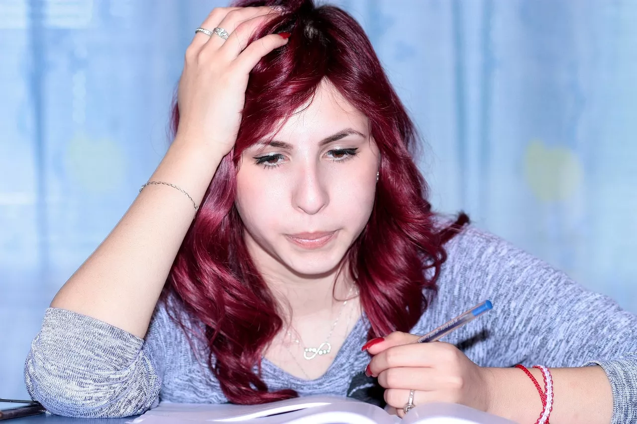 Eine Frau lernt bzw. studiert. Eine junge Frau sitzt an einem Schreibtisch.