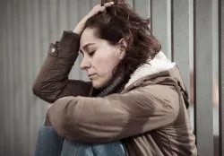 A vulnerable woman looking depressed with her head in her hands A vulnerable woman looking depressed with her head in her hands.
