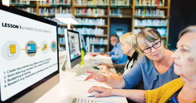 A group of senior learners participates in an AI-enabled digital literacy workshop in a library. ...