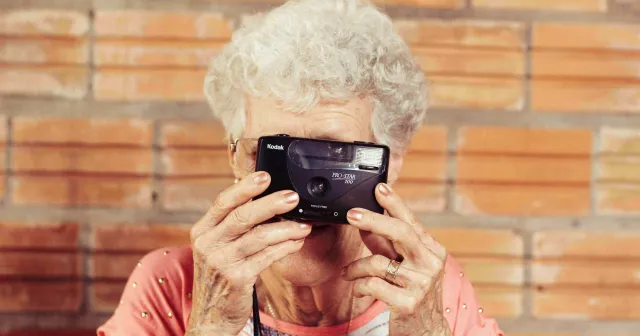 Mujer sosteniendo una cámara.