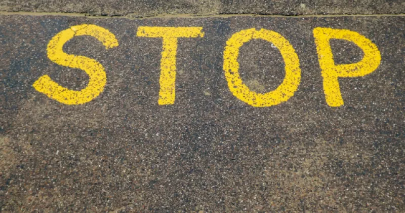 żółty napis STOP napisany na ulicy.