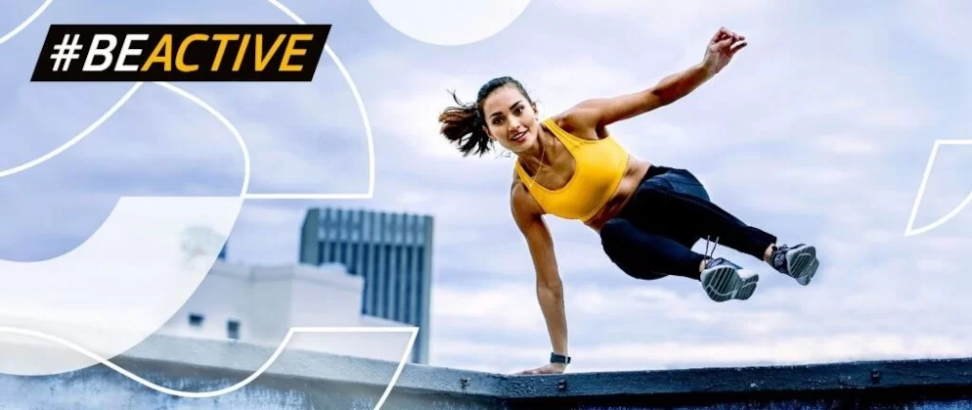 Młoda kobieta w stroju sportowym wykonuje skok przez przeszkodę